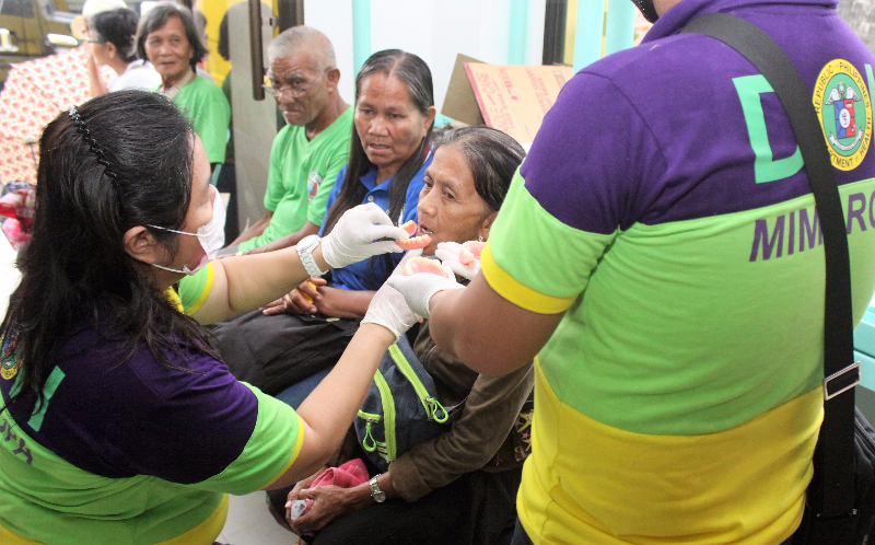 DOH PHOTO. A team of dentists from the Provincial Health Office inserts a new set of dentures to an elderly during the launching of Ngipin Para kay Tatang at Inang (NgiTI) which provided free set of dentures to 50 senior citizens held at the Romblon State Univeristy in Odiongan, Romblon.