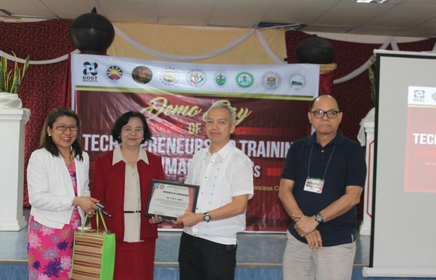 Dr. Luis G. Sison as he receives a certificate of appreciation for his contribution to the Technopreneurship Training Program